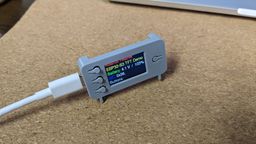 A grey 3D printed case for a circuit board, sitting on cork on a table